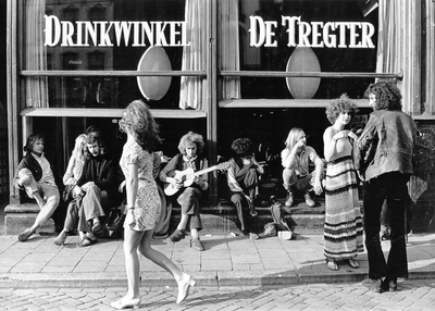 351252 Afbeelding van een groepje jongeren (hippies) op de stoep bij de Drinkwinkel De Tregter (Oudegracht 148) te Utrecht.